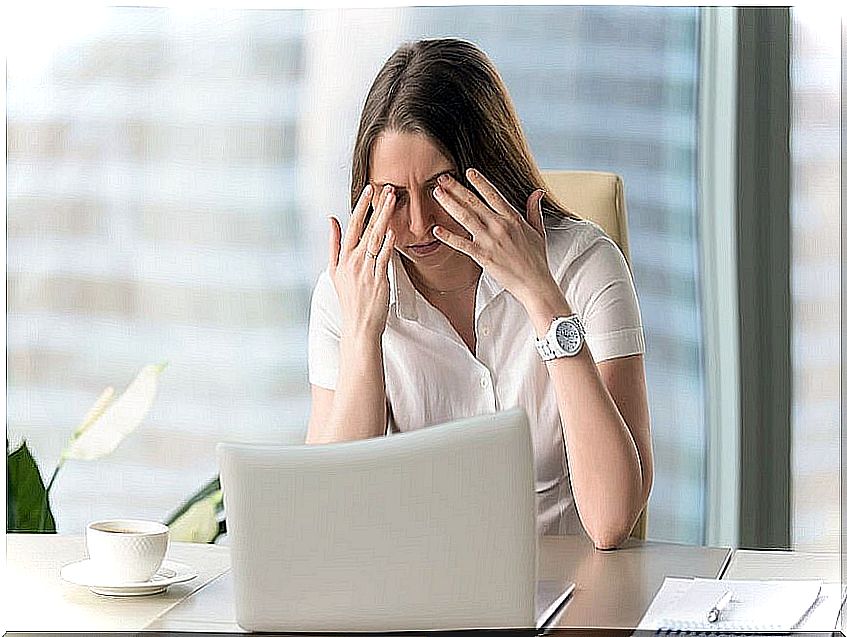 Stressed woman in front of the computer getting an eye massage.