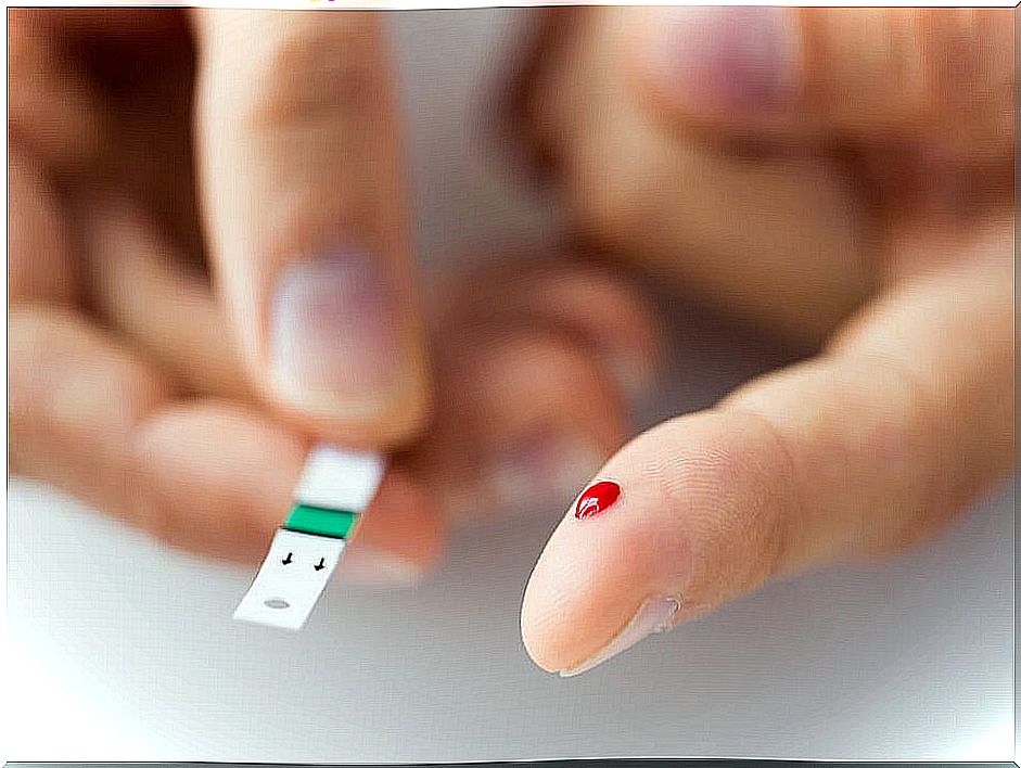 Finger with drop of blood and test strip