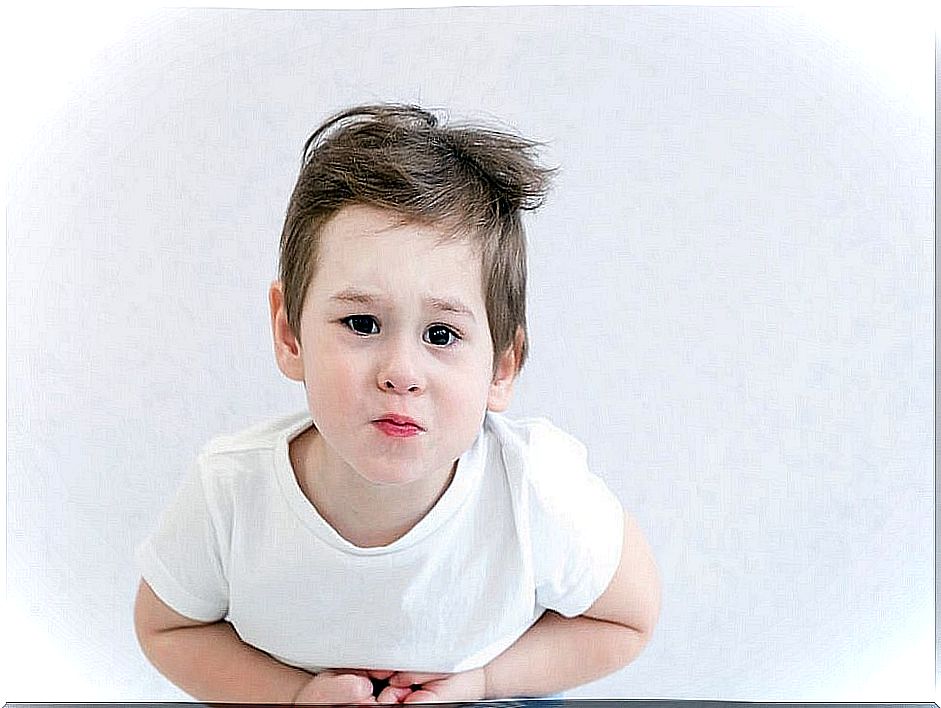 Child with hands on stomach and a gesture of pain.