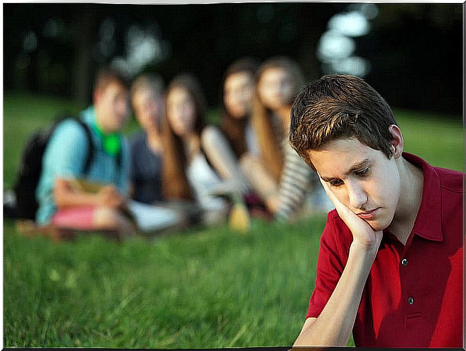 Group of teenagers laughing at a boy.