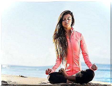 Woman doing yoga on the beach to relax