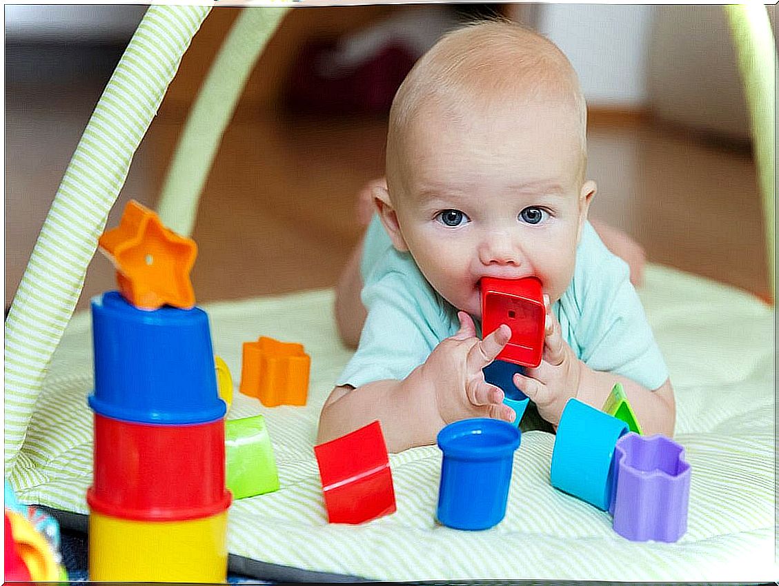 Baby plays with cubes and stares at something.